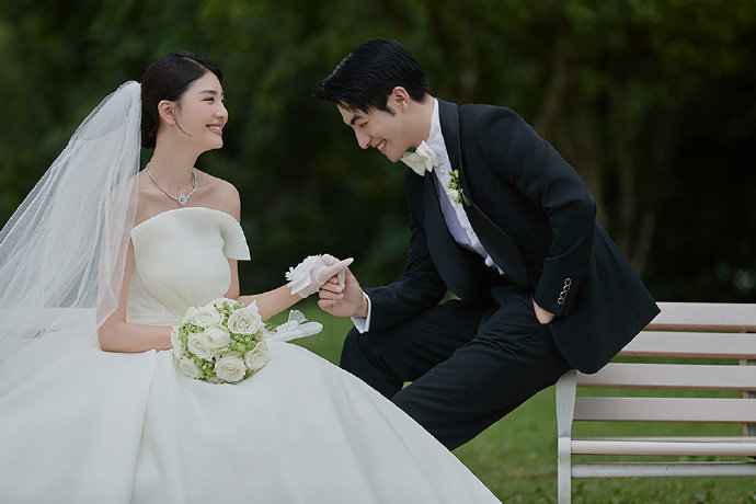 户外草坪婚纱照 抹胸婚纱拖地头纱是亮点